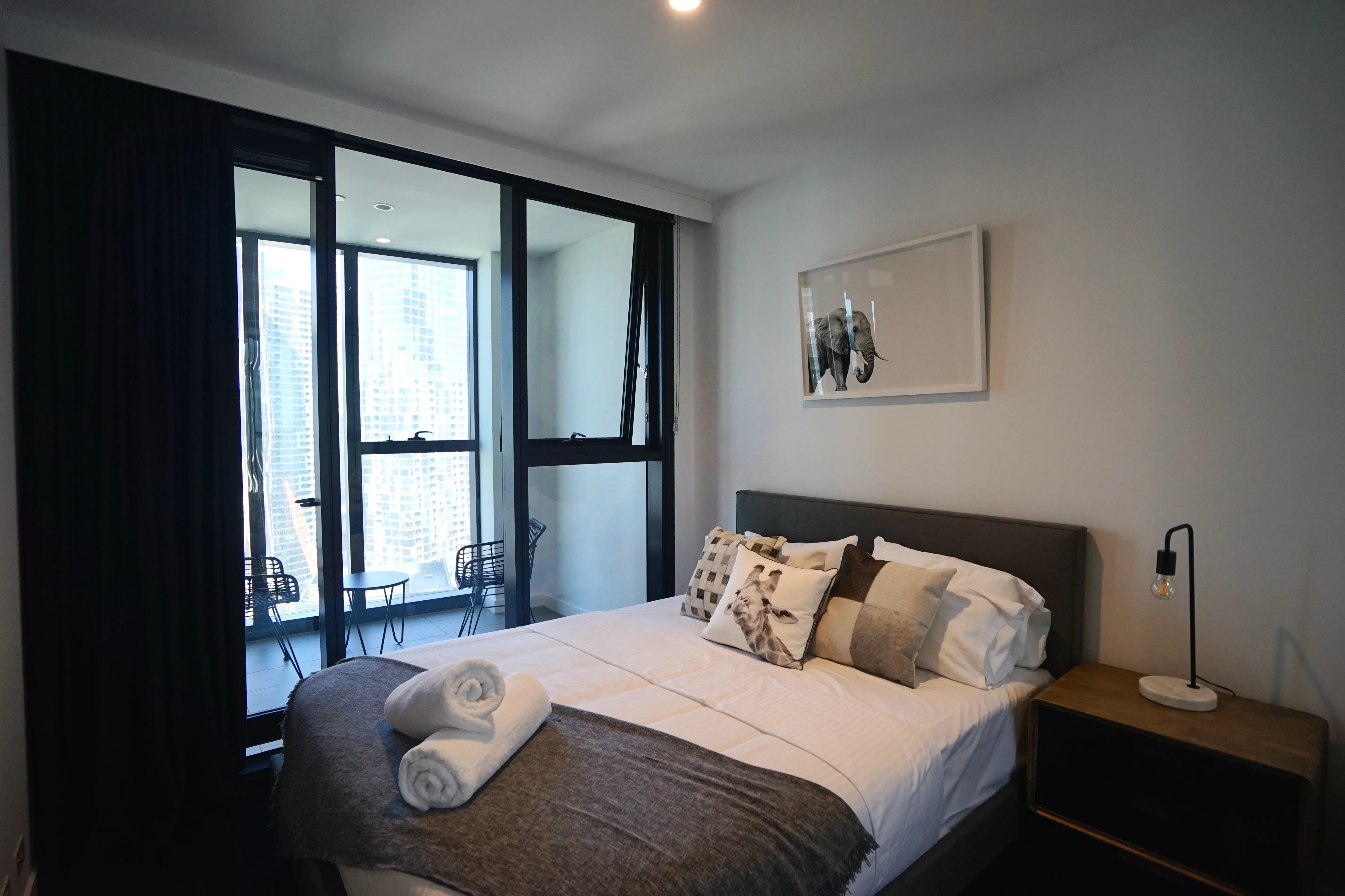 Bed with pillows towels lamp side table bedroom at Belong Melbourne CBD in Melbourne Student Accommodation