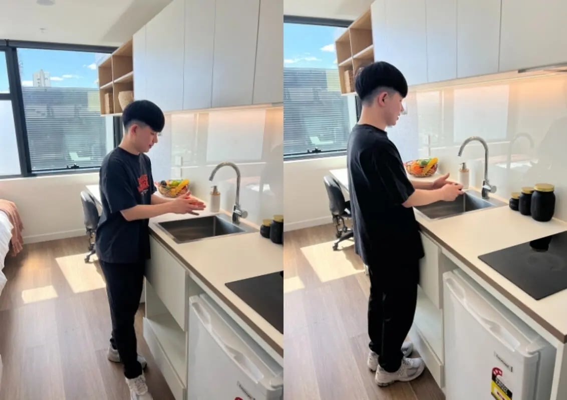Man washing hands at sink desk bed kitchen at UniLodge Melbourne Flagstaff in Melbourne Student Accommodation