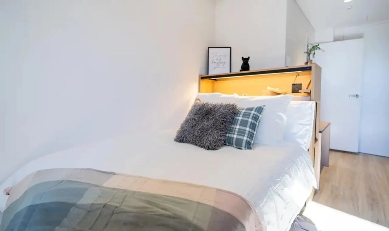 Bed with pillows and throw blanket bedroom at The Switch Kensington in Sydney Student Accommodation