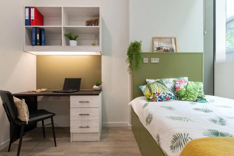 Desk bed shelf plants and laptop Bedroom at Flora Building - Hoxton in London Student Accommodation