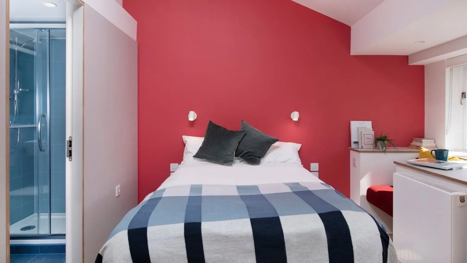 Bed with plaid blanket and shower bedroom at Scape Kings Cross in London Student Accommodation