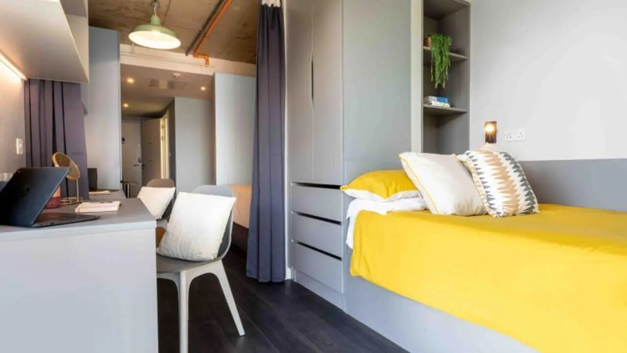 Bed desk chair and wardrobe student room at iQ Aldgate in London Student Accommodation