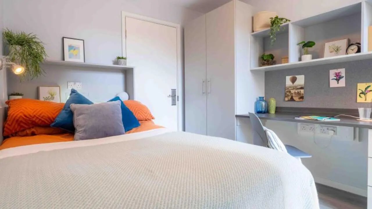 Bed with pillows desk and wardrobe bedroom at iQ City in London Student Accommodation