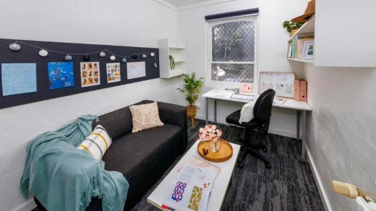 Sofa desk and plants student accommodation living room at UniLodge @ UC - Campus West & Guginya in Canberra Student Accommodation