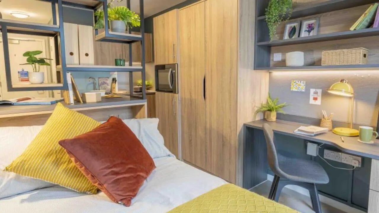 Bed with pillows and desk with lamp Bedroom at iQ Hammersmith in London Student Accommodation