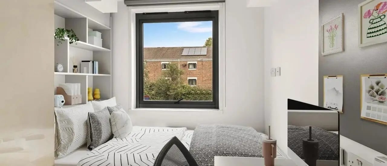 Bed pillows shelves and window view bedroom at Chapter Islington in London Student Accommodation