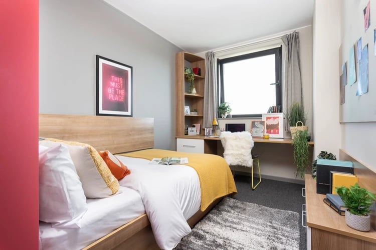 Bed desk bookshelf chair window and rug bedroom at Sky Plaza in Leeds Student Accommodation