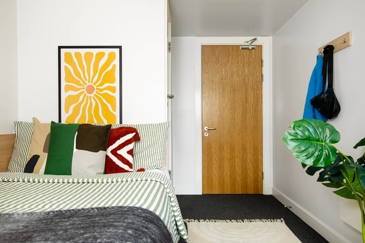 Bed with colorful pillows art on wall Bedroom at Liberty Park in Leicester Student Accommodation