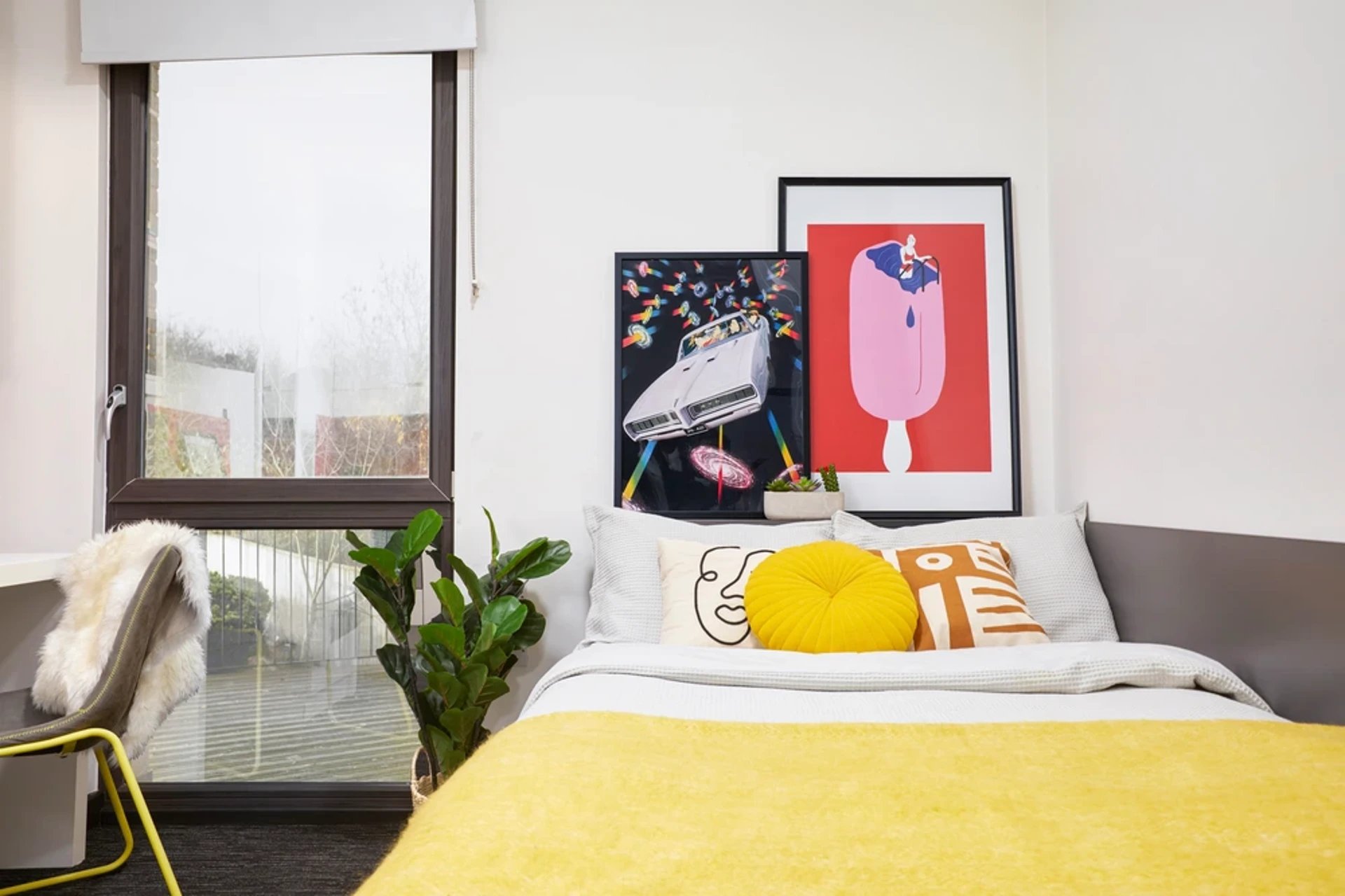Bed with yellow blanket art and plant bedroom at Athena Studios in Birmingham Student Accommodation