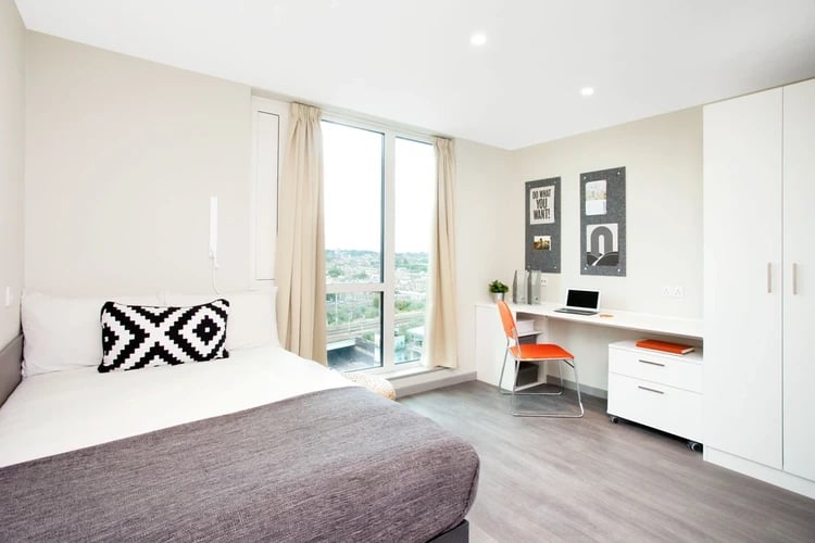 Bed desk orange chair and closet bedroom at Stapleton House in London Student Accommodation