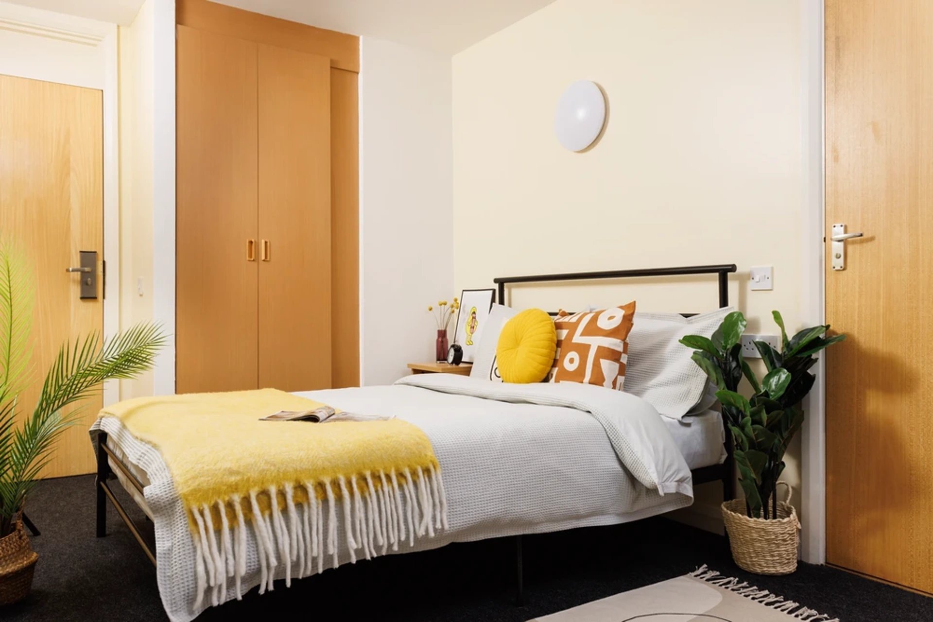 Bed with yellow blanket and plants bedroom at Westhill Hall in Sheffield Student Accommodation