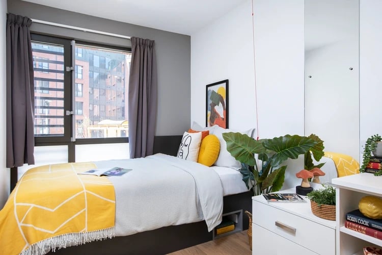 Bed with yellow throw artwork and plant bedroom at Morriss House in Nottingham Student Accommodation