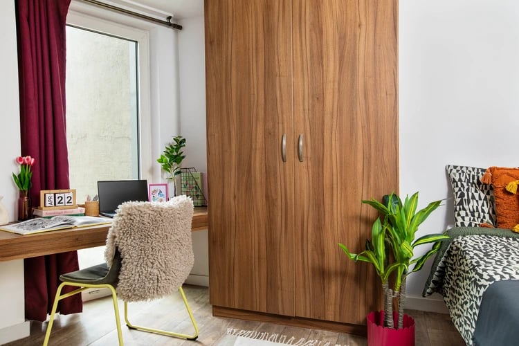 Wooden wardrobe desk laptop fluffy chair bedroom at Student Living Heights in London Student Accommodation
