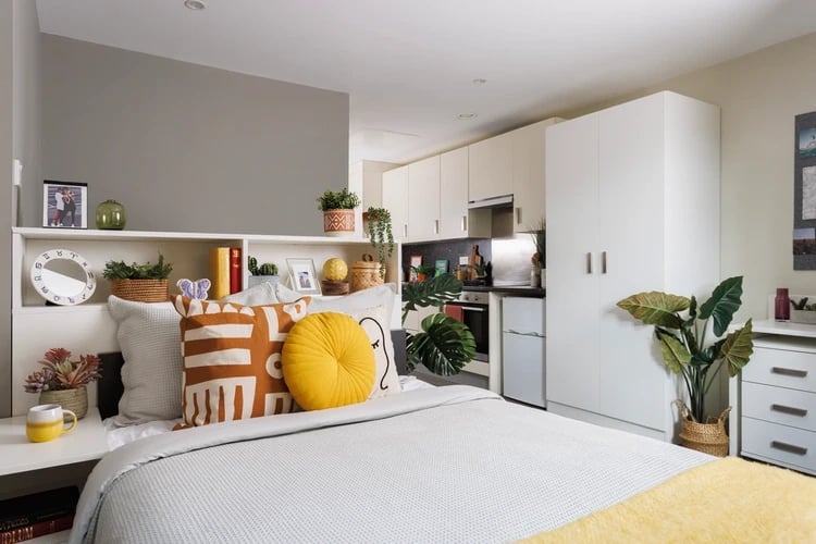 Bed with pillows kitchenette and storage bedroom at The Old Printworks in Edinburgh Student Accommodation