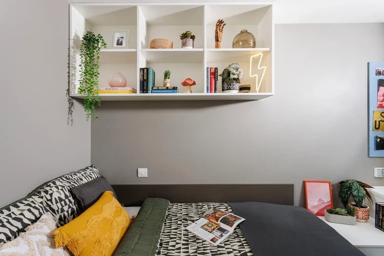 Bed with patterned bedding shelves and decor bedroom at Olympic Way in London Student Accommodation