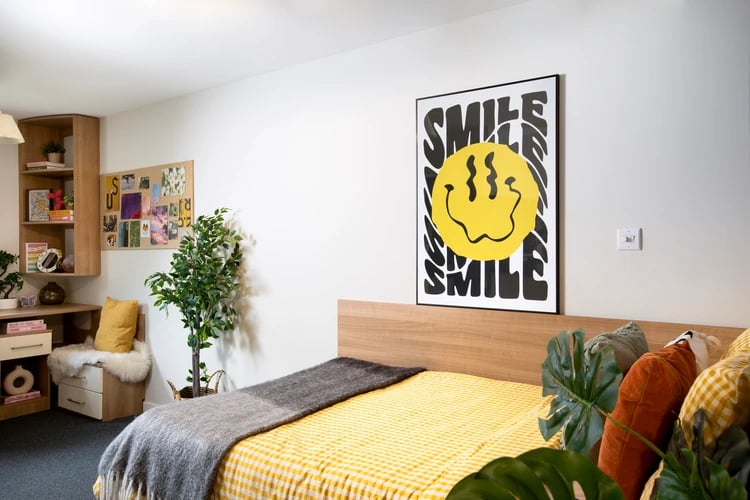 Bed with yellow gingham bedding and smile poster Bedroom at Elizabeth Croll House in London Student Accommodation