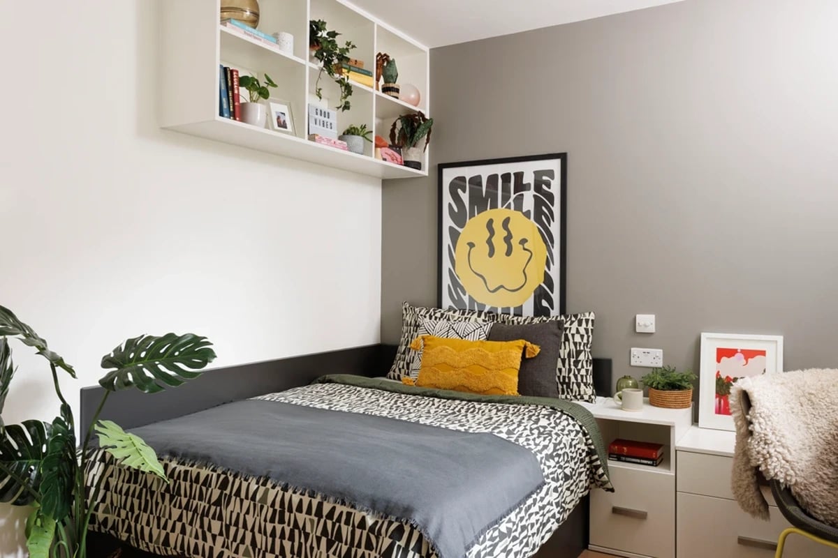 Bed with patterned bedding pillows artwork Bedroom at Houghall Court in Durham Student Accommodation