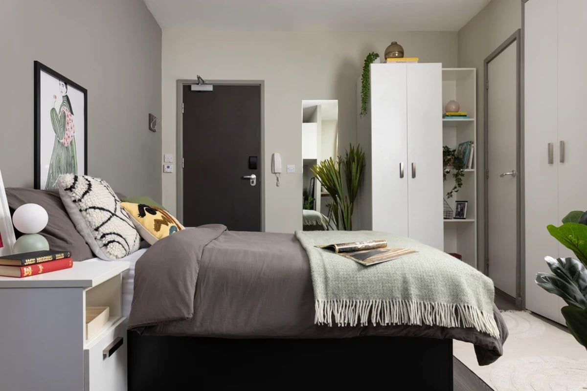 Bed pillows artwork wardrobe and bookshelves bedroom at Piccadilly Point in Manchester Student Accommodation