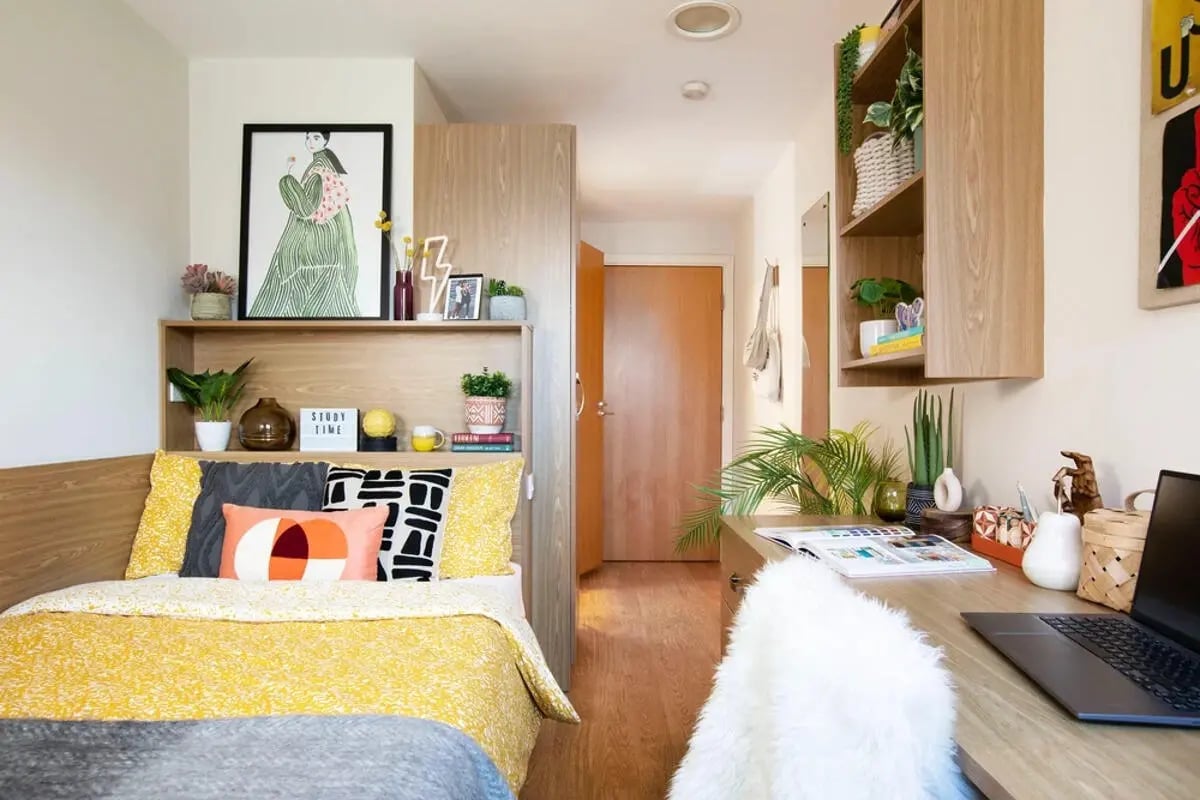 Bed with yellow bedding and art desk bedroom at Thurso Street in Glasgow Student Accommodation