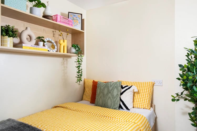 Yellow checkered bedding and decorative pillows bedroom at Castle Court in Leicester Student Accommodation