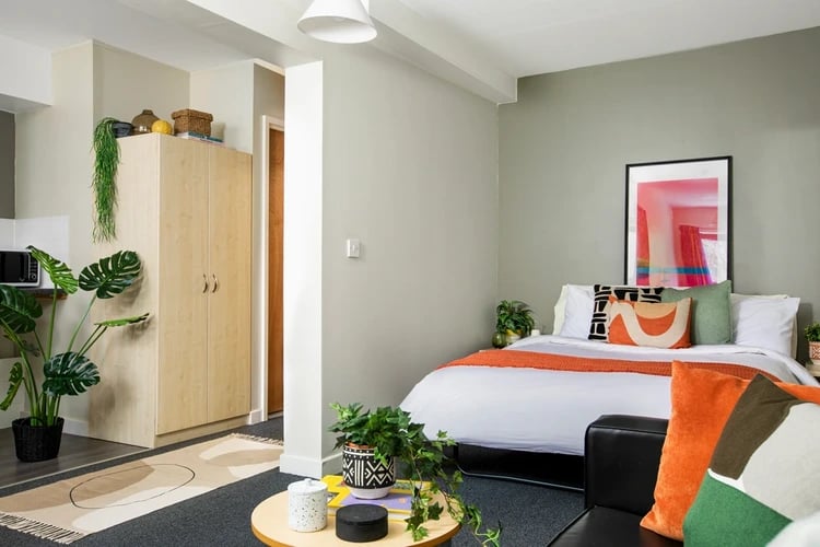 Bed desk plants wardrobe and microwave Studio Apartment at Rahere Court in London Student Accommodation