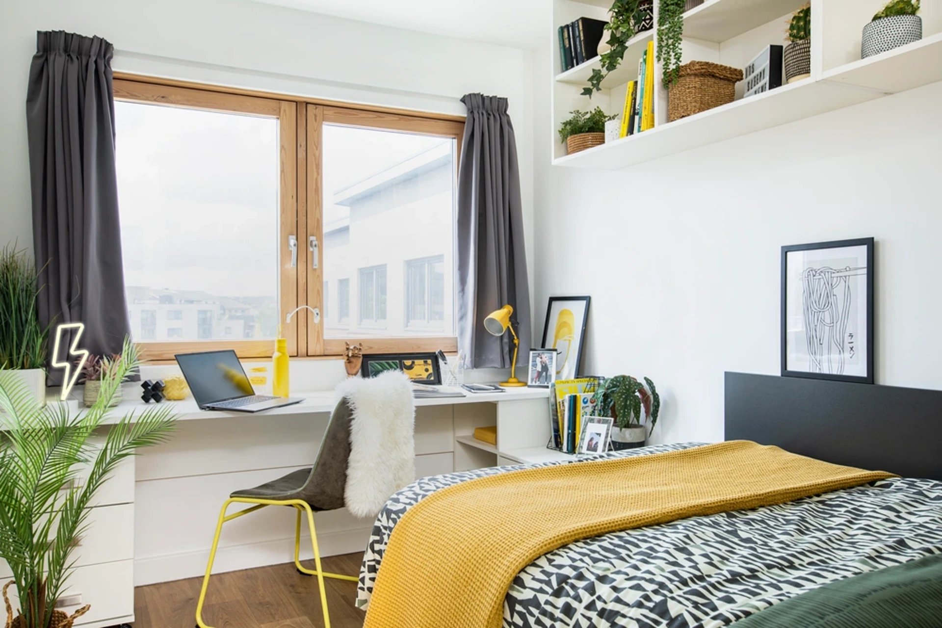 Desk plants laptop chair and bed bedroom at Piccadilly Court in London Student Accommodation