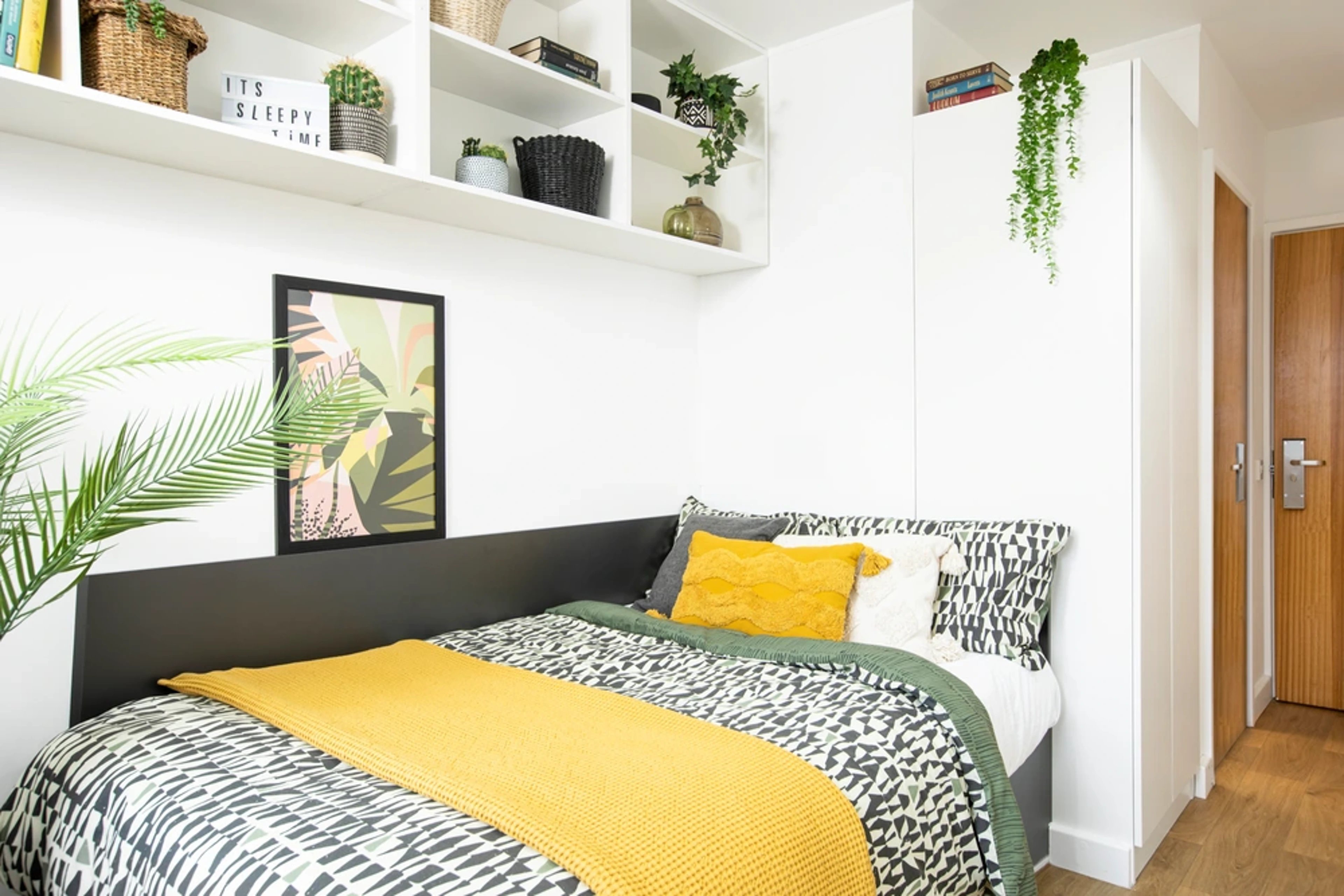 Bed with yellow throw and art bedroom at Piccadilly Court in London Student Accommodation