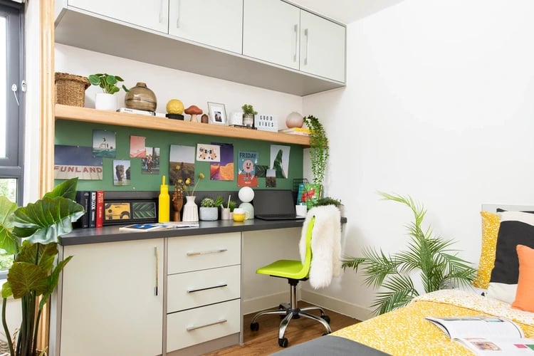Desk with laptop plants and artwork study area at Tramworks in Glasgow Student Accommodation