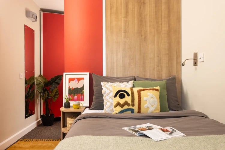 Bed with abstract pillows and artwork Bedroom at Chalmers Street in Edinburgh Student Accommodation