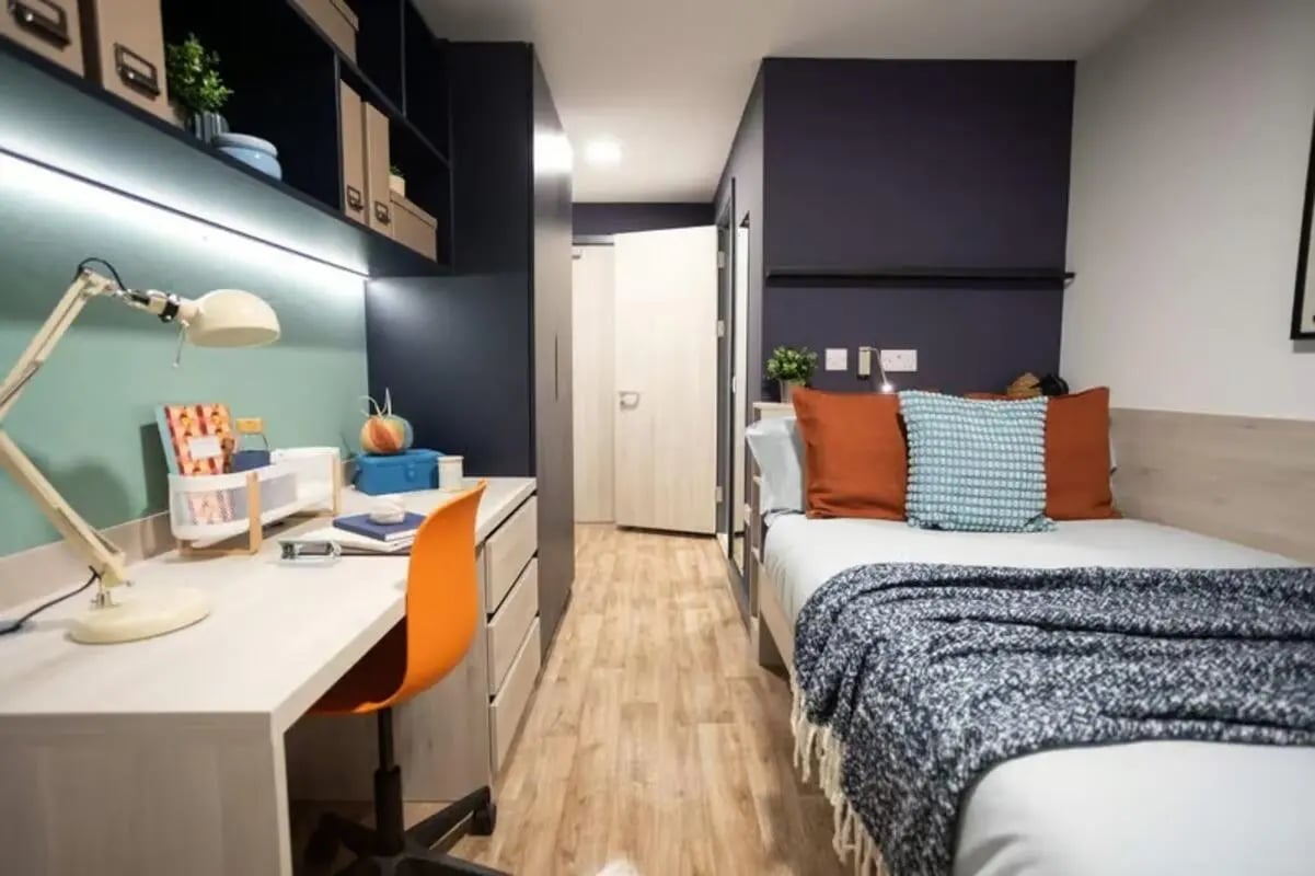 Desk lamp orange chair bed bedroom at Tribeka in Leeds Student Accommodation