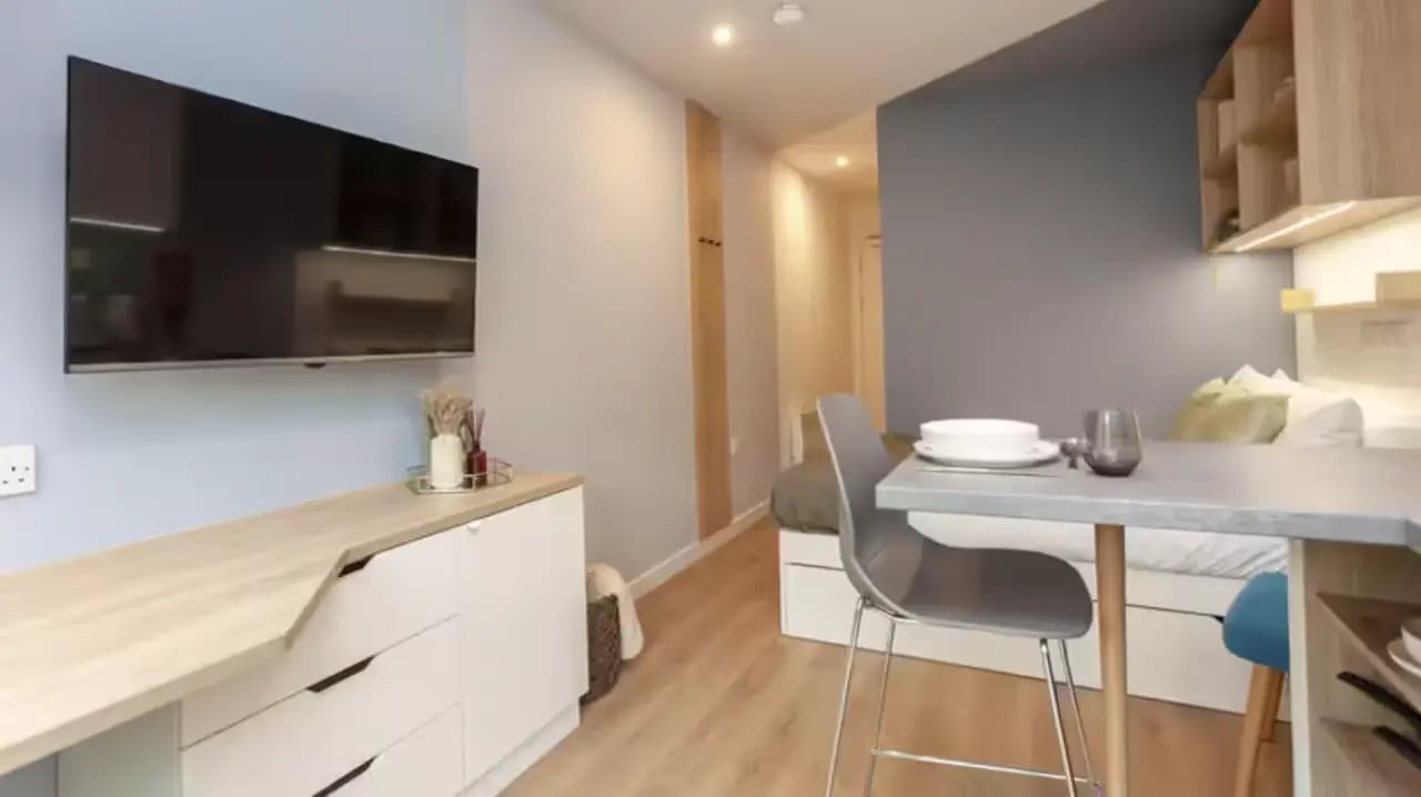Flat screen TV white cabinet grey chair dining table bedroom kitchen at Mayfield Residences in Edinburgh Student Accommodation