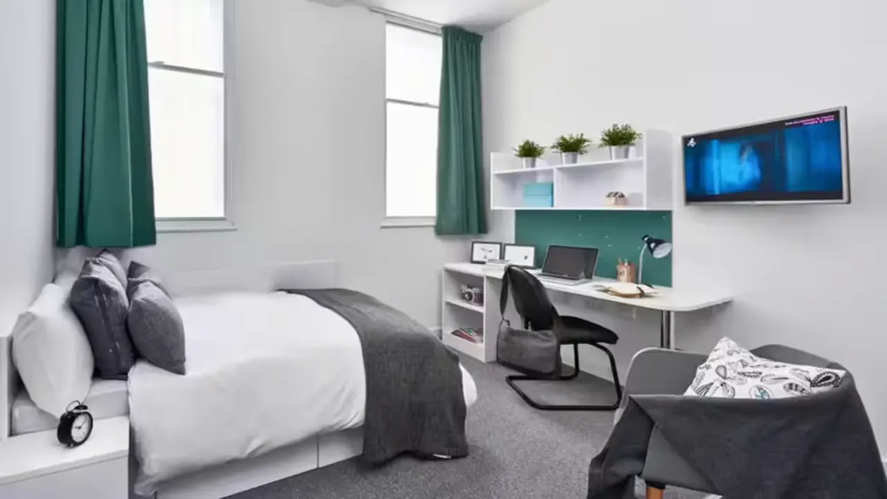 Bed desk chair television and plants bedroom at The Glassworks Leicester in Leicester Student Accommodation