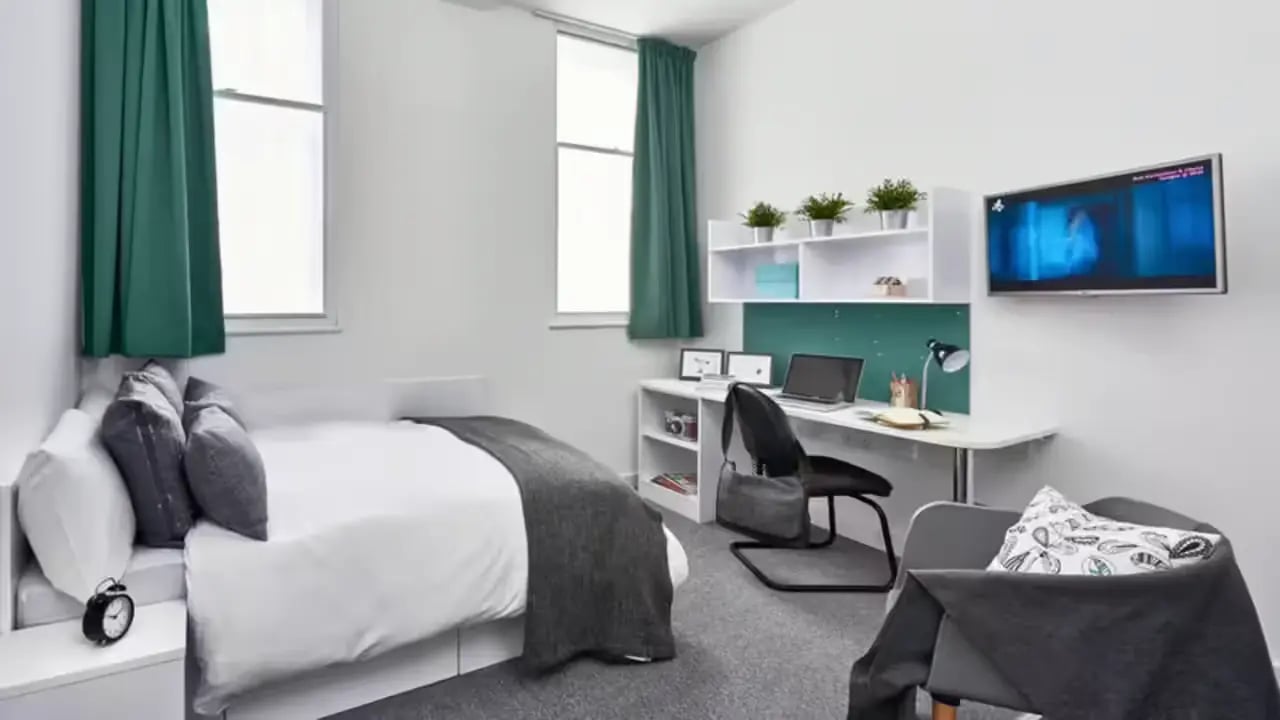Bed desk shelves television laptop and chair bedroom at The Glassworks Leicester in Leicester Student Accommodation