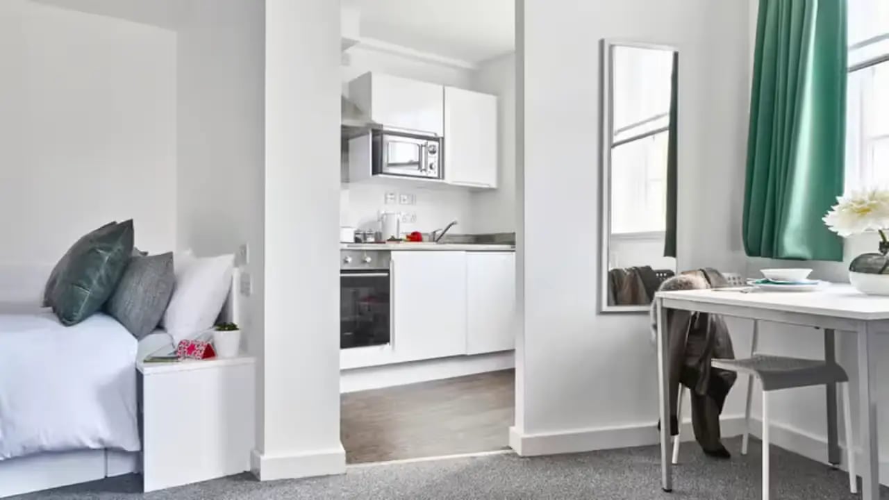 Bed pillows nightstand kitchen area and dining table at The Glassworks Leicester in Leicester Student Accommodation