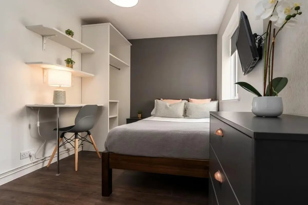 Desk lamp chair shelves bed television bedroom at 28 Church Street in Nottingham Student Accommodation