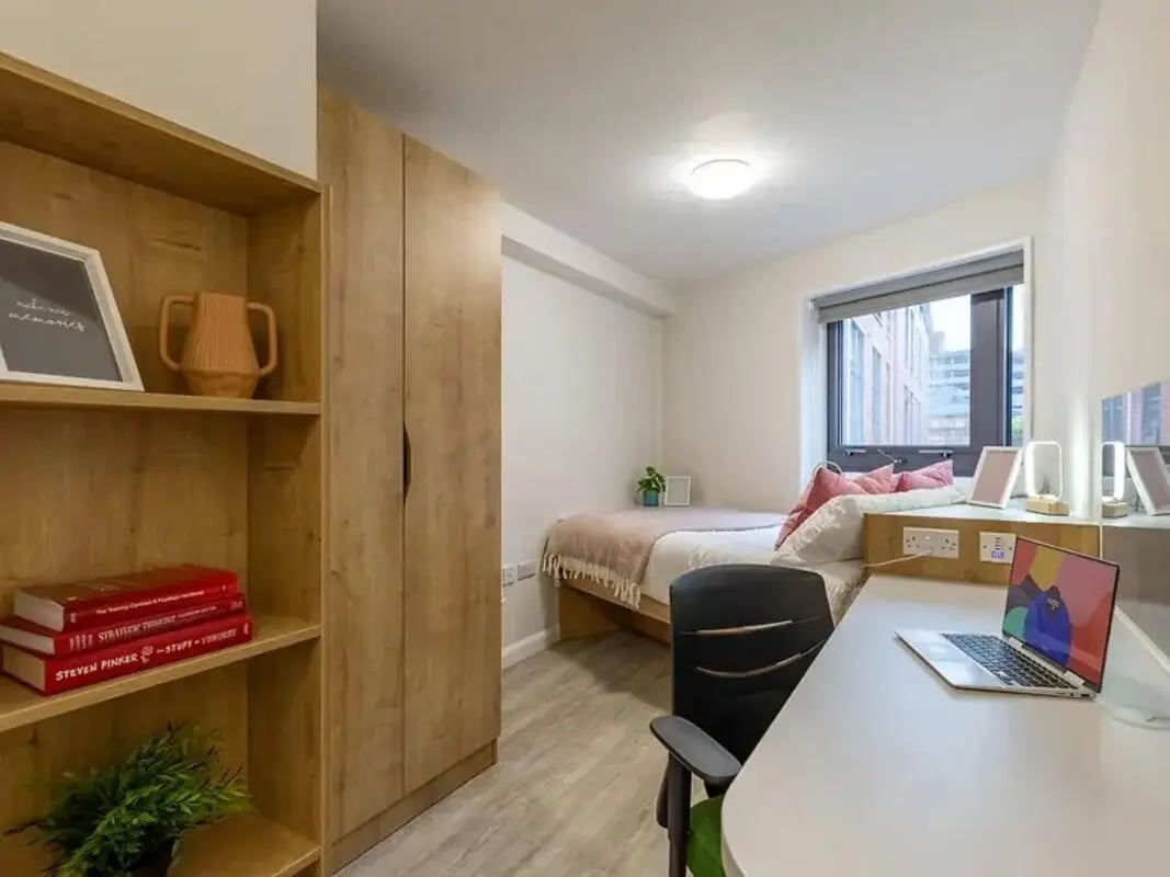 Bookshelf wardrobe bed desk laptop and chair bedroom at Yugo Goldsmith Court in Nottingham Student Accommodation