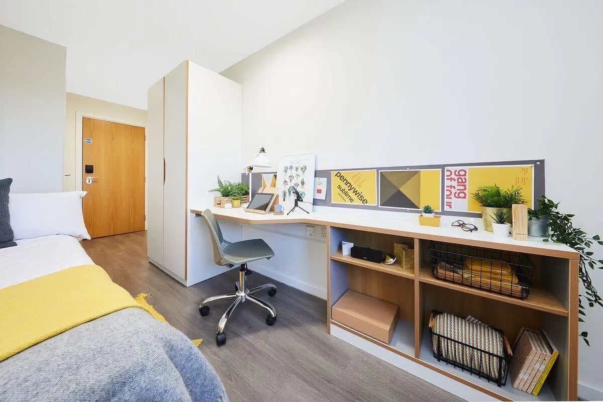 Bed desk plants shelves door bedroom study area at Collegiate Merlin Heights in Leicester Student Accommodation