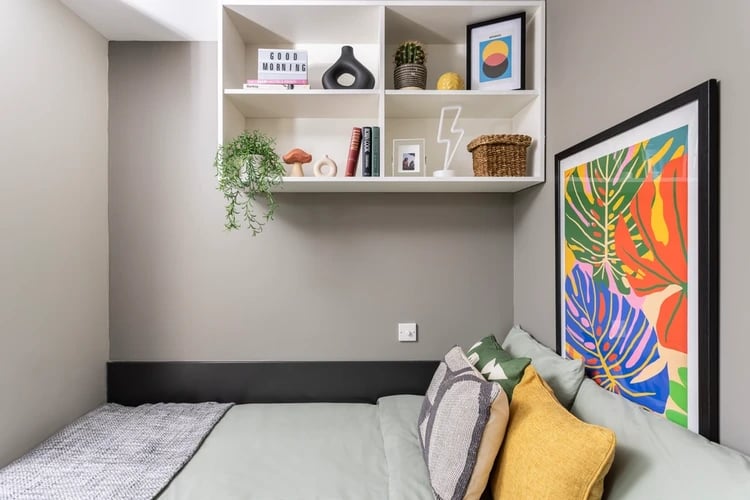 Bed with pillows shelves and artwork bedroom at Newgate Court in Newcastle Upon Tyne Student Accommodation