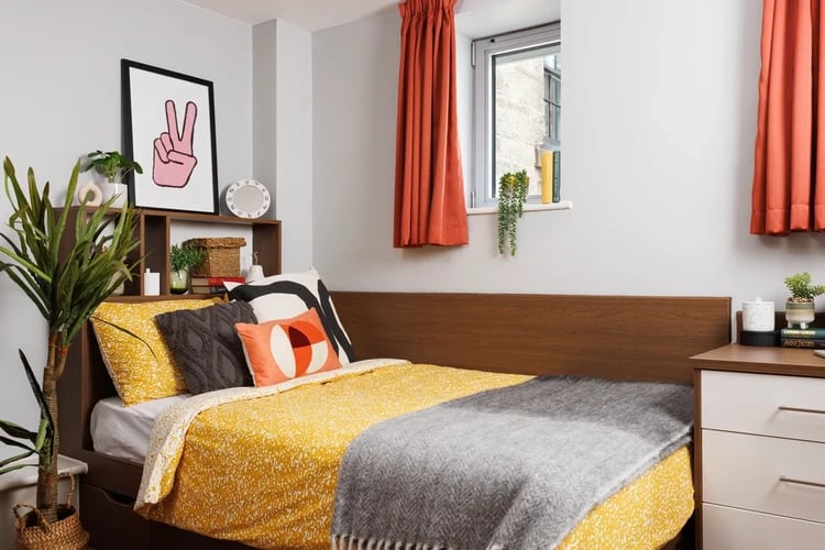 Bed with yellow bedding and plants bedroom at Sugarhouse in Edinburgh Student Accommodation