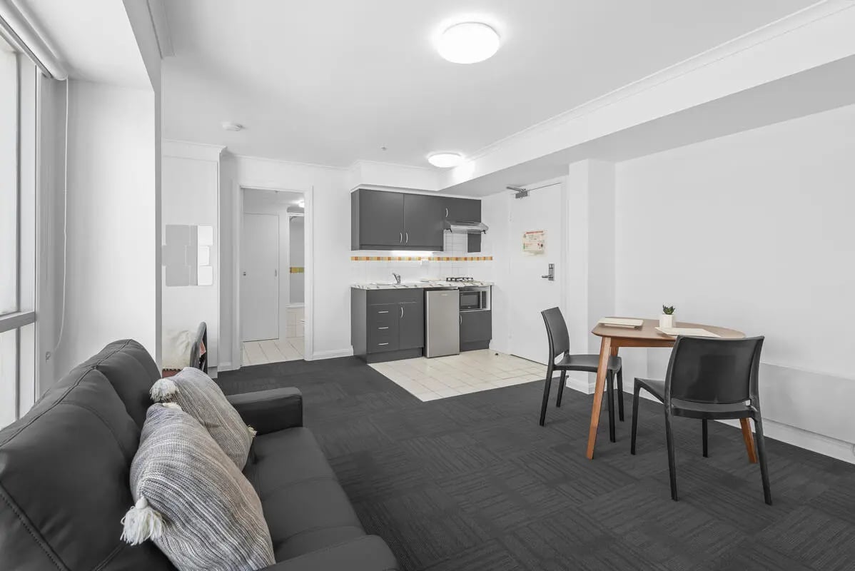 Sofa kitchen dining table living room kitchen at Student Living on Flinders in Melbourne Student Accommodation