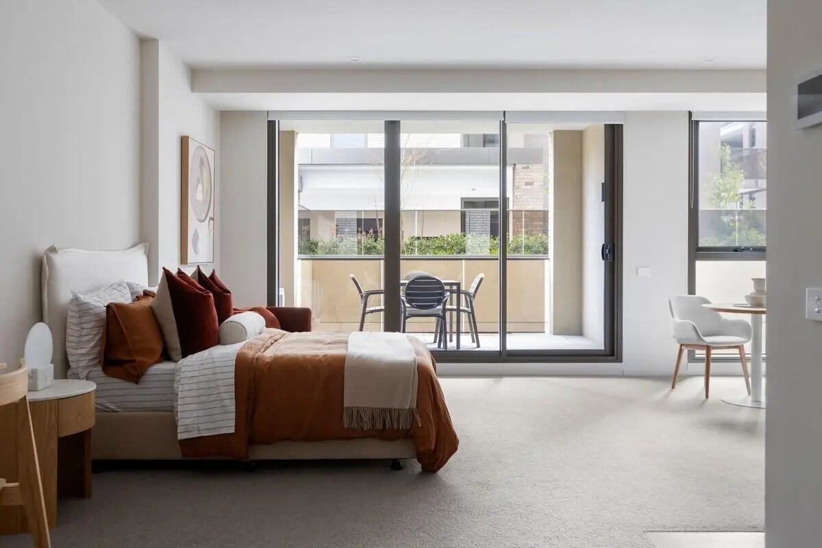 Bed balcony table chairs apartment living room at Realm Caulfield in Melbourne Student Accommodation