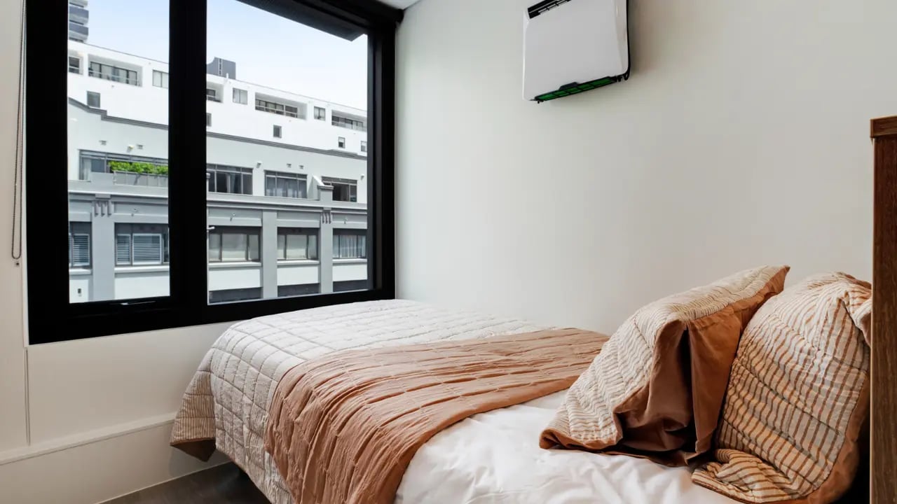 Bed with pillows and blanket window bedroom at UniLodge Auckland Central in Auckland Student Accommodation