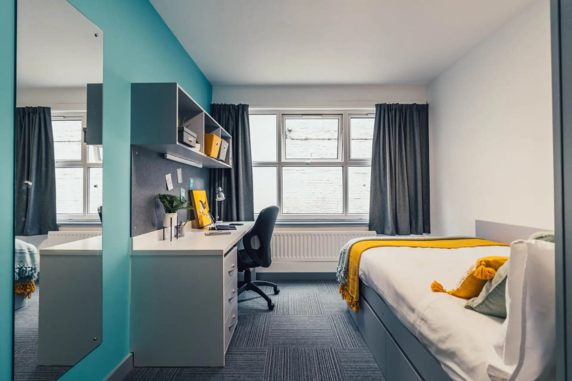 Bed desk mirror and window student accommodation bedroom at Pennine House Leicester in Leicester Student Accommodation