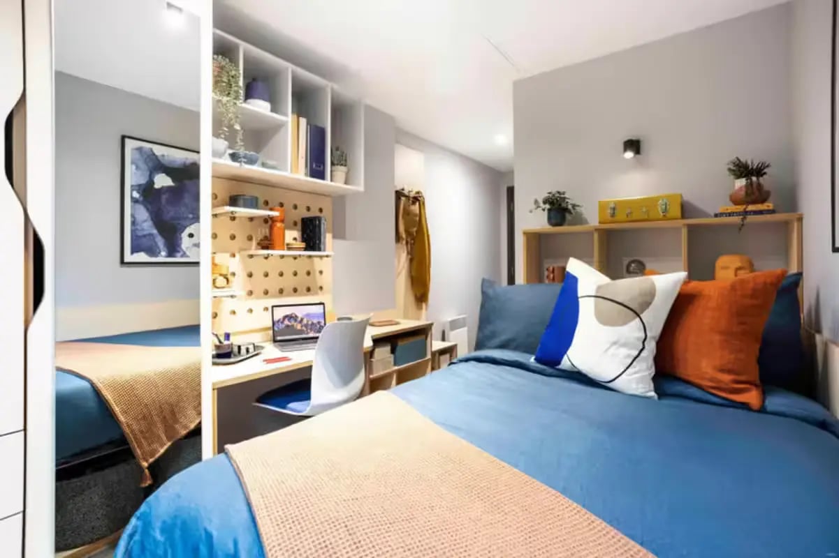 Blue bed desk laptop shelves artwork Bedroom at Aster House in Belfast Student Accommodation