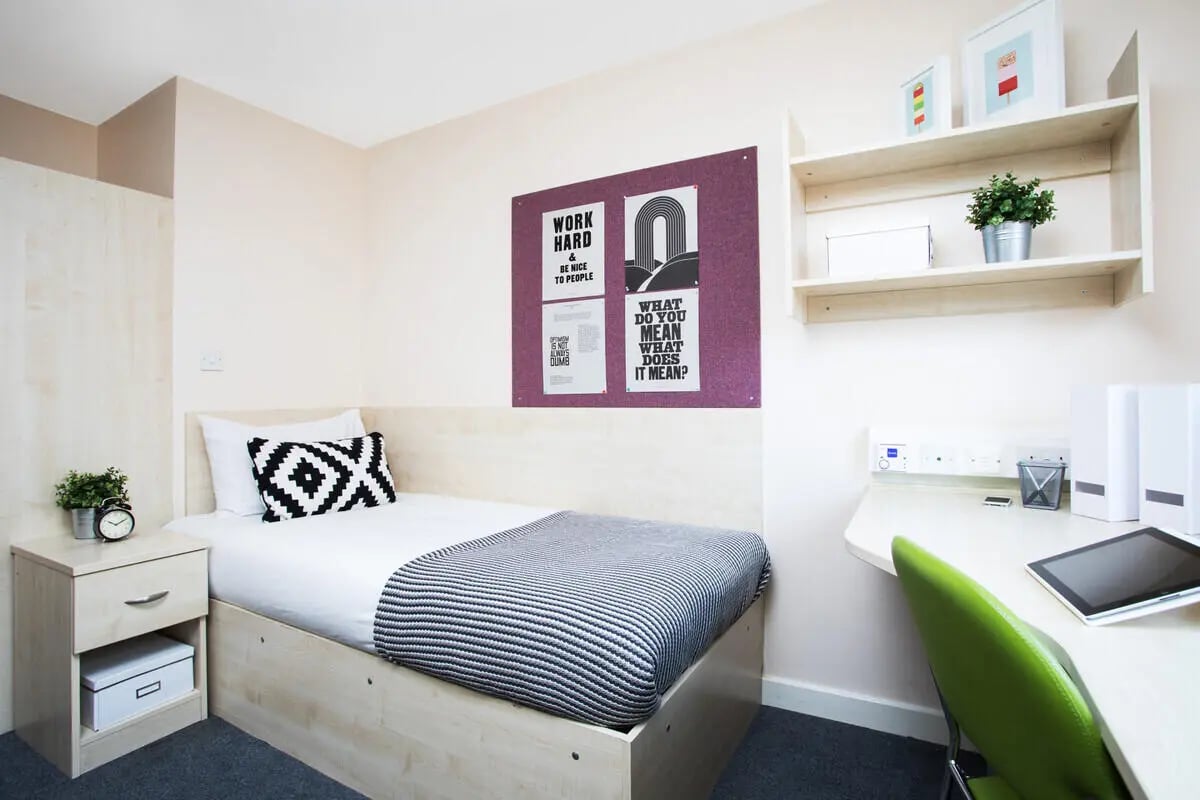 Bed desk alarm clock plant and motivational posters bedroom at The Grange Leicester in Leicester Student Accommodation