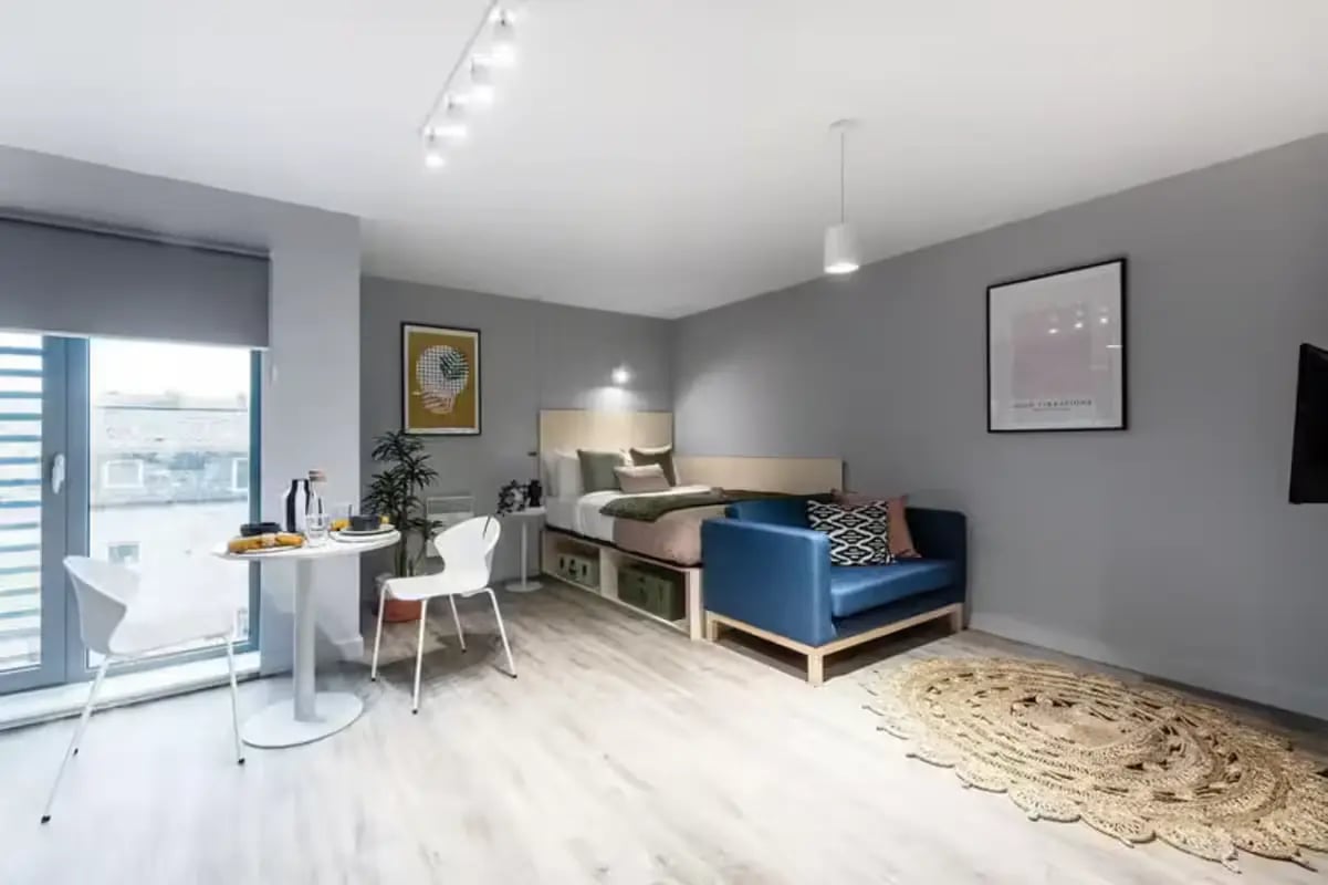 Bed sofa table chairs and rug studio apartment at Huxley Studios in Edinburgh Student Accommodation