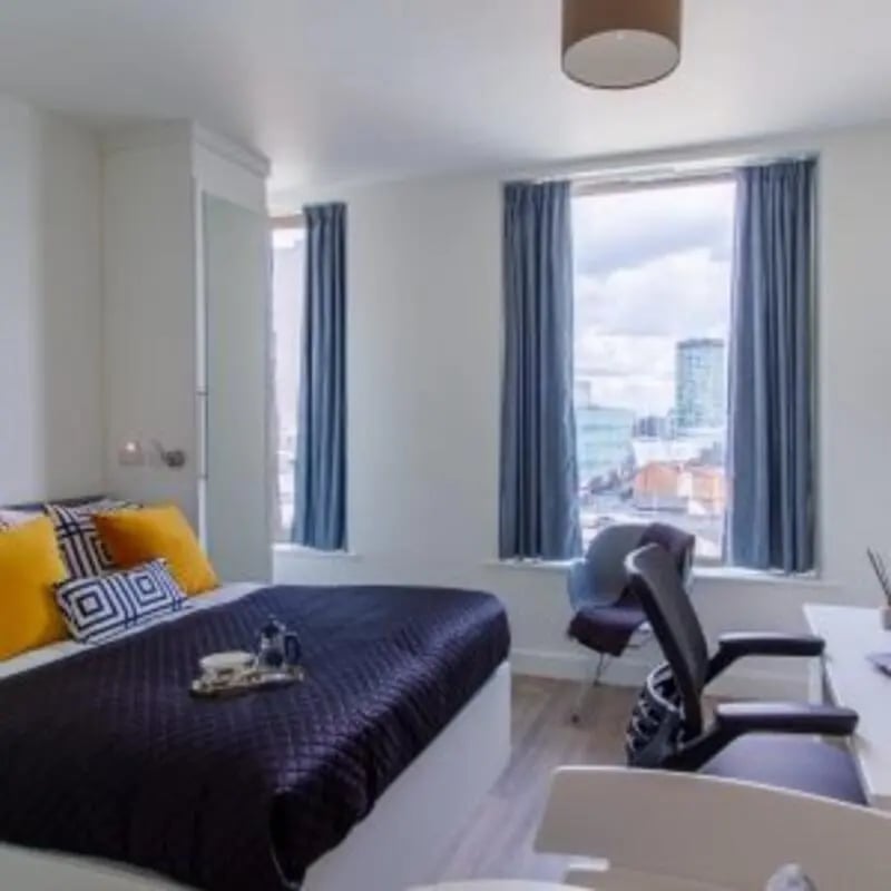 Bed with pillows and tray bedroom study area at Kensington House in Birmingham Student Accommodation