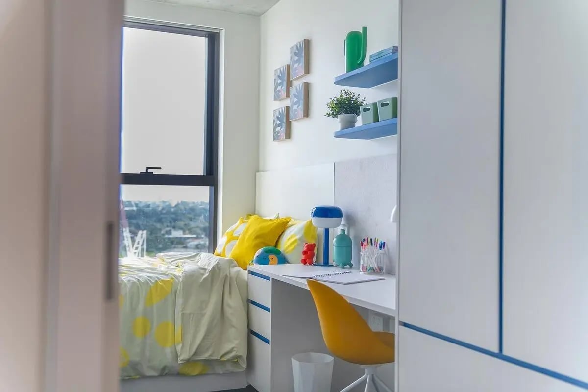 Bed desk and yellow chair student bedroom at Scape Kensington in Sydney Student Accommodation
