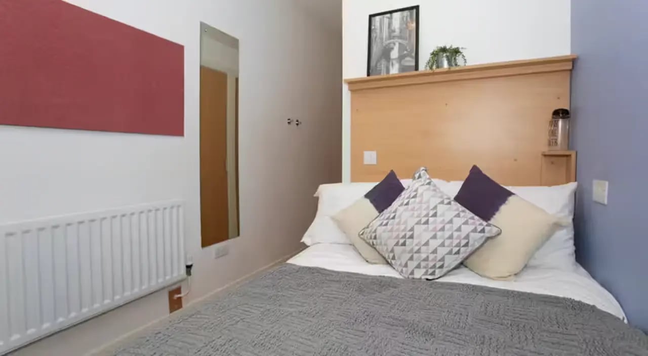 Bed pillows radiator artwork and mirror bedroom at 200 Cowgate in Edinburgh Student Accommodation