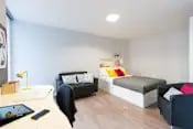 Bed sofa desk with tablet student room exterior at Glassyard Building in London Student Accommodation
